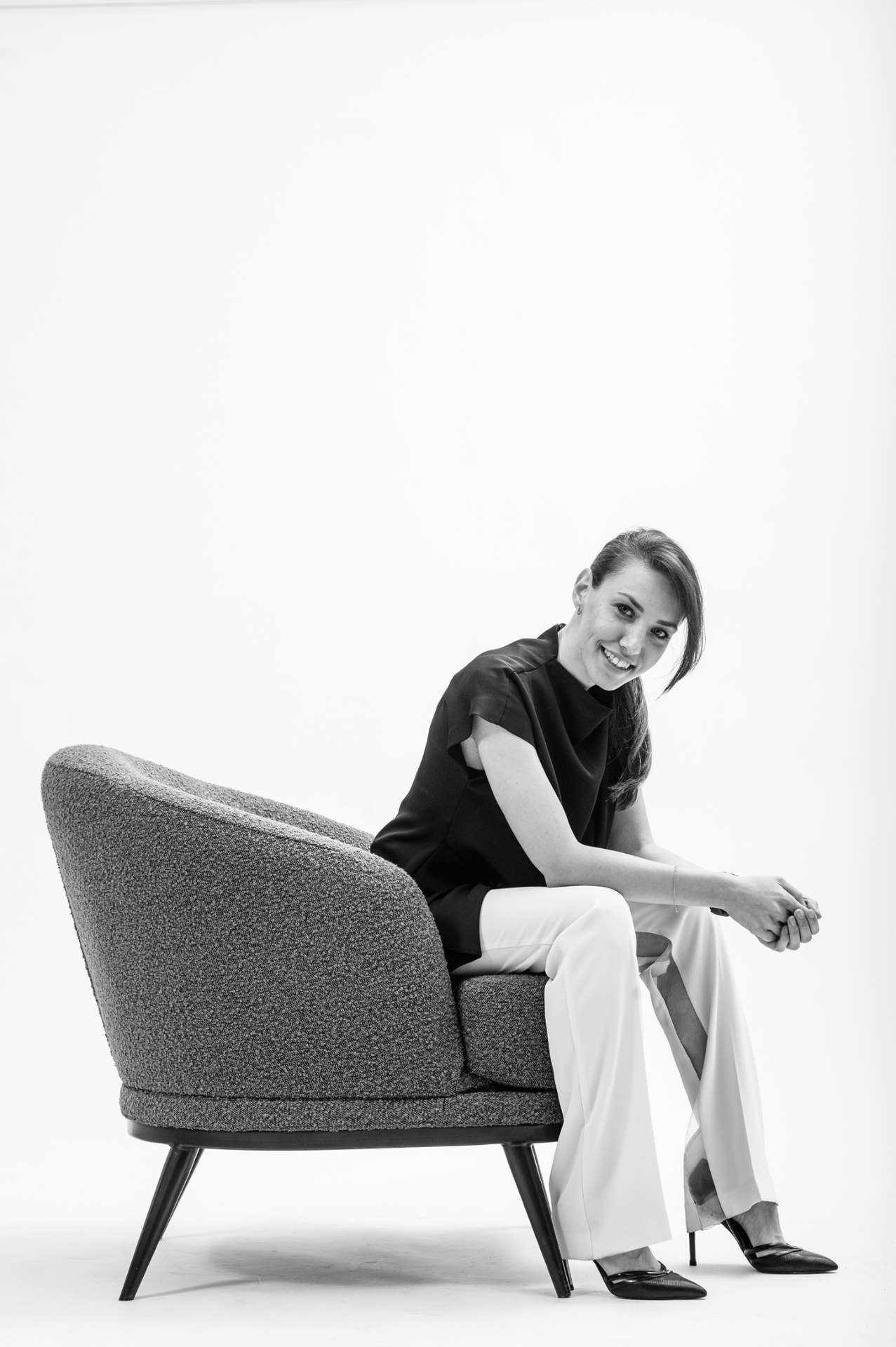 Teodora seated on a boucle chair